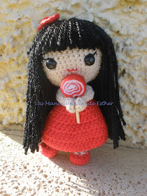 Muñeca realizada a crochet con vestido rojo y piruleta de fieltro