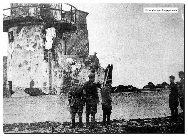 Red Army soldiers watch a Japanese lighthouse which they burnt at Cape Kokutan, Shumshu Islands, in Kuril Islands
