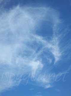bright blue sky with wispy clouds swirling