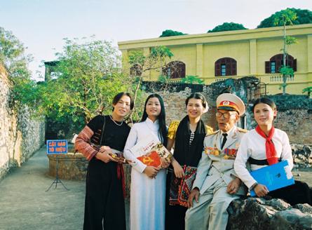 Ðại tá Lò Văn Sôn, cán bộ lão thành cách mạng kể chuyện với thanh niên các dân tộc bên di tích lịch sử Nhà tù Sơn La.