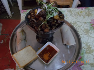 "Half Raw Beef" with pancakes  served on a small sizzling hot  coal burner.