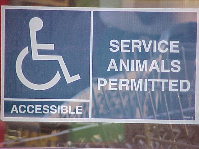 Sign with blue background and white print, reading Accessible and Service Animals Permitted, with wheelchair symbol