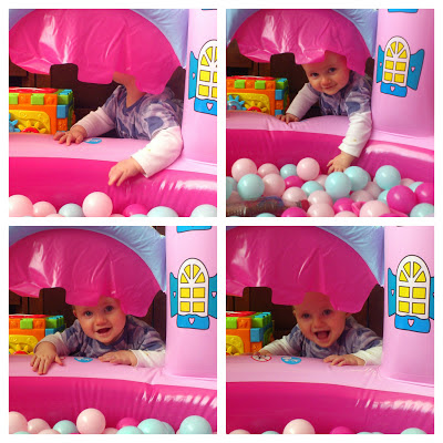 gorgeous cute baby playing peekaboo in inflatable castle ball pit