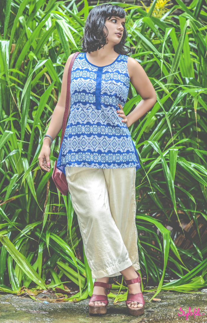 Wearing a Liva infused sheer blue printed tunic and cream culottes, Dayle Pereira of Style File India styles her personal style outfit with a Forever 21 burgundy sling bag, clogs, an embellished hairband and dark lips on a background of greenery in the monsoons as it rains 