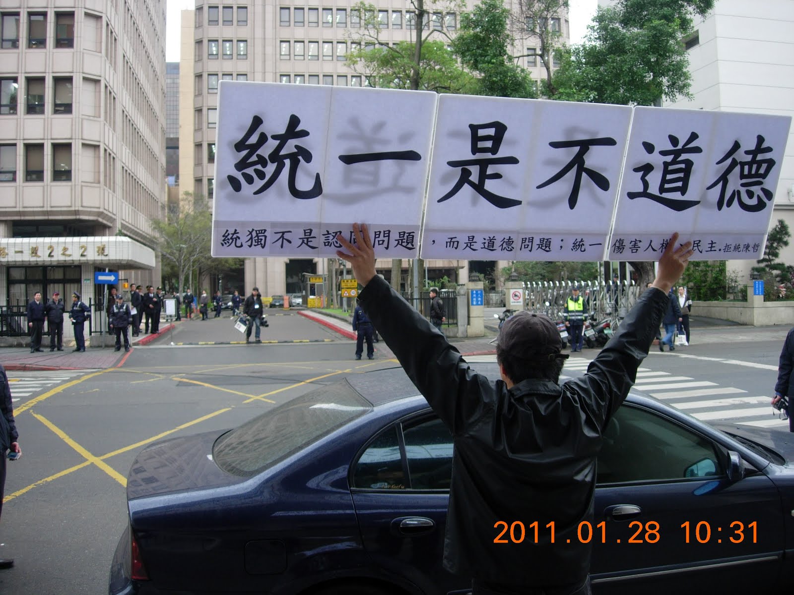 陳立民 Chen Lih Ming (陳哲) 舉「統一是不道德的！」看板，上附「統獨不是認同問題，而是道德問題；統一傷害人權與民主，是不道德的。」20110128在陸委會20週年場抗議馬英九總統。