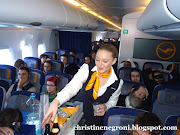 A smiling Lufthansa flight attendant serves coach passengers (flight attendants luft )