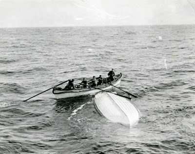 A life boat waiting to be taken aboard rescue ship RMS Carpathia near a capsized life boat