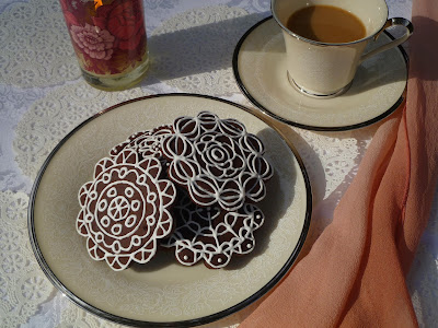 pinks, doilies, white piped dark-chocolate tea biscuits, coffee, china