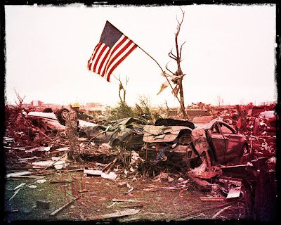 Battered US flag flying over debris
