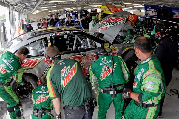 Crew members work on the car of Dale Earnhardt Jr., driver of the #88 Diet  Mountain Dew Chevrolet