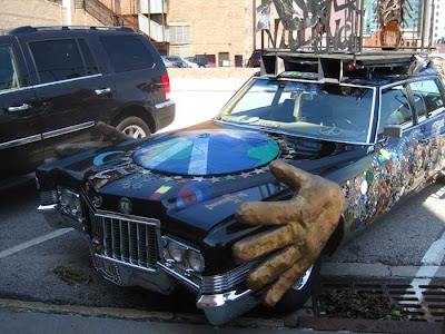 Cadillac art car with giant fins and a big paper mache hand on the side
