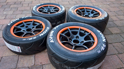 Orange rimmed, 8 spoke 13 inch R500 track day wheels with Avon ZZR tyres and painted tyre wall lettering