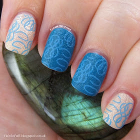 Teal and champagne colored manicure with light blue stamping over textured polish.