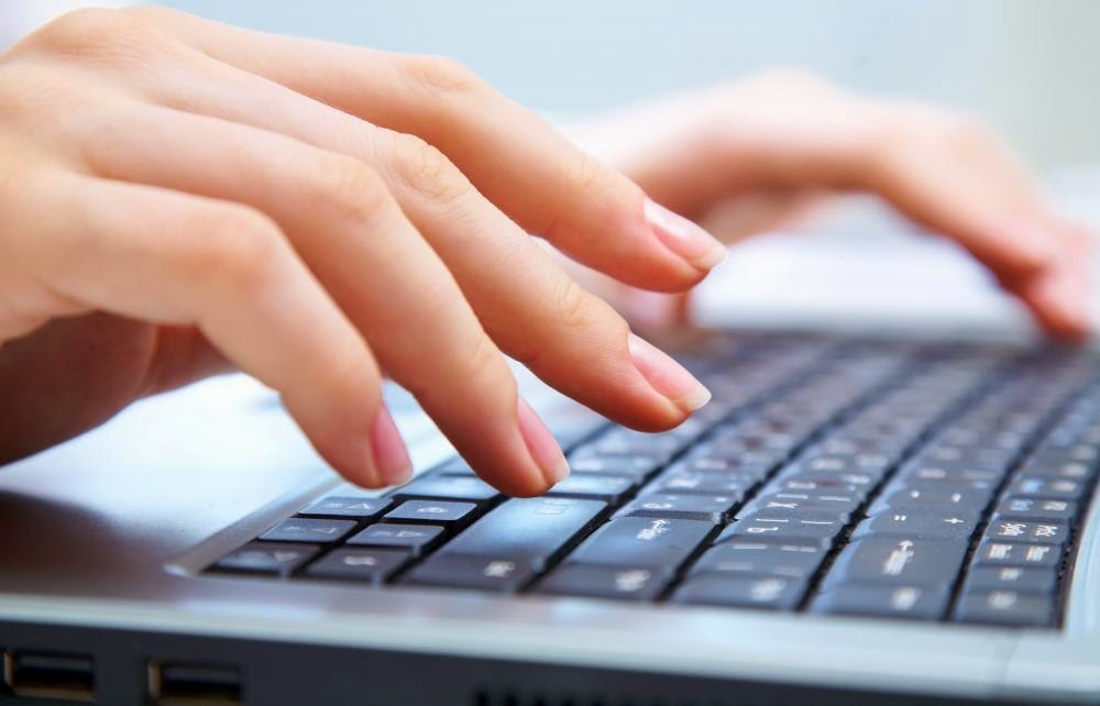 hands typing on a computer keyboard