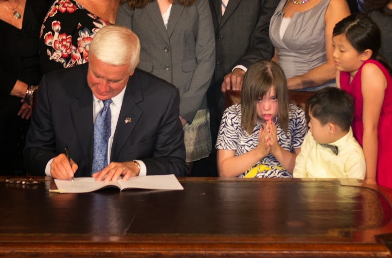 Chloe praying during signing of "Chloe's Law"