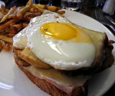 Croque Madame. Thick cut house made Brioche, ham, Béchamel, melted gruyère, topped with an egg, Sunny side up.