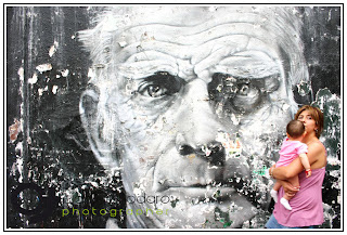 Mother with baby, murale as background, in Notting Hill - by Claudio Todaro