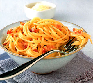 Spaghetti alla carbonara served in a bowl with a fork.