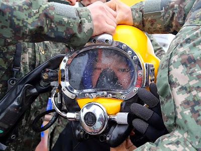 Recovery operation ... a diver wears a helmet to look for people still missing from the s