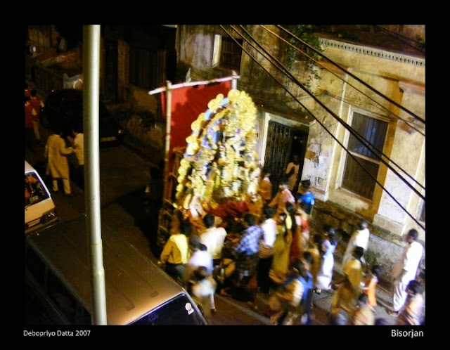 Meandering through North Calcutta's narrow streets, the bisorjon procession makes its way towards the Ganges.