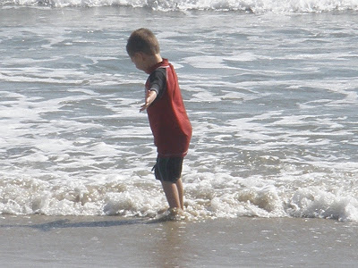 little boy playing in the waves