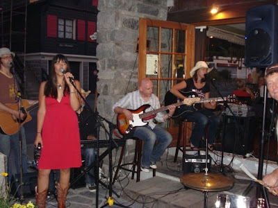 Patty rocking down with her band, the Chambelles, in a dress and Cowboy boots