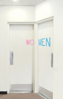 two washroom doors adjacent to each other. One reads wo, the other  reads men