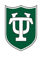Green shield design with white letters U and T overlapping and serving as the decorative image on the shield.