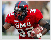 Football player in red uniform with white SMU lettering carries a football in a game.
