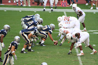 Rice University football lines up to snap the ball at the line of scrimmage.