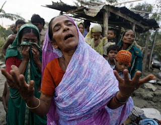 Cyclone Kills Hundreds in Bangladesh: Hasu Begum (R) and her sister Niru react after their 80-year-old mother was killed, when their house collapsed during the cyclone, in Bakerganj, 340 km (211 miles) southwest of Dhaka, November 17, 2007.  (Rafiqur Rahman/Reuters) 