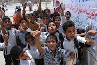 Iraqi children watch the grand opening ceremonies of the Jameat Market in Basra. The children were released from school early to attend the community-building event. (Royal Navy photo by Leading Airman Jannine B. Hartmann)