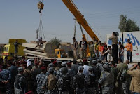Children jump onto a flat-bed truck and celebrate as a crane removes several concrete barriers from a marketplace in Samarra, Iraq, March 23.