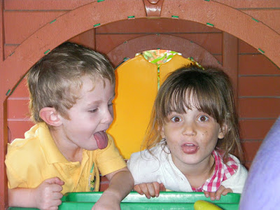grubby children sticking tongues out b+q garden playhouse