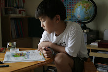 In his favorite sitting (or squatting) style: Clay's  concentrating on his spelling lesson.