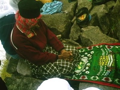 Warga yang salat bersama sesajian beras dan telur dalam kantung plastik
