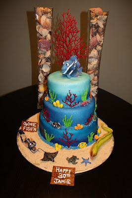 A birthday cake with plastic fish and sea life on it