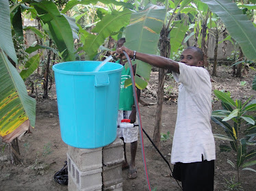 Pastor Peter fills the bucket with water