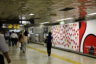駅内でGoogle マップのピンのデザインの大看板を示す画像。
