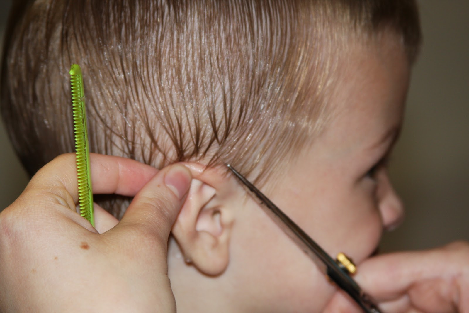 cutting a boy's hair with scissors
