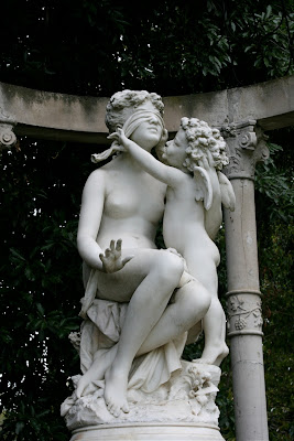 Woman blindfolded by cherub statue