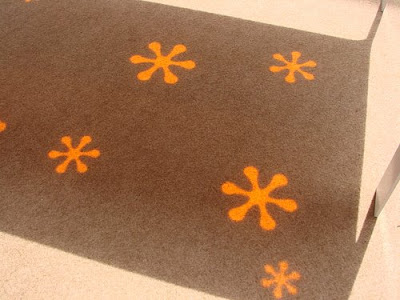 Hoc Die Design, mesa con flores naranjas reflejadas en el suelo