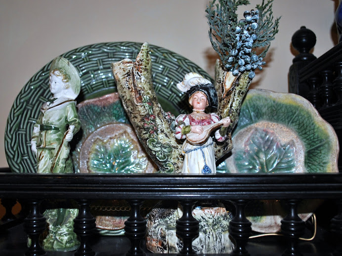 A Staffordshire spill vase and figure blends nicely with a collection of majolica plates.
