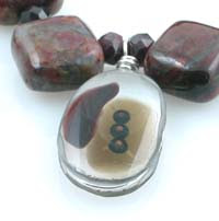 fused glass pendant with 3 garnet inclusions