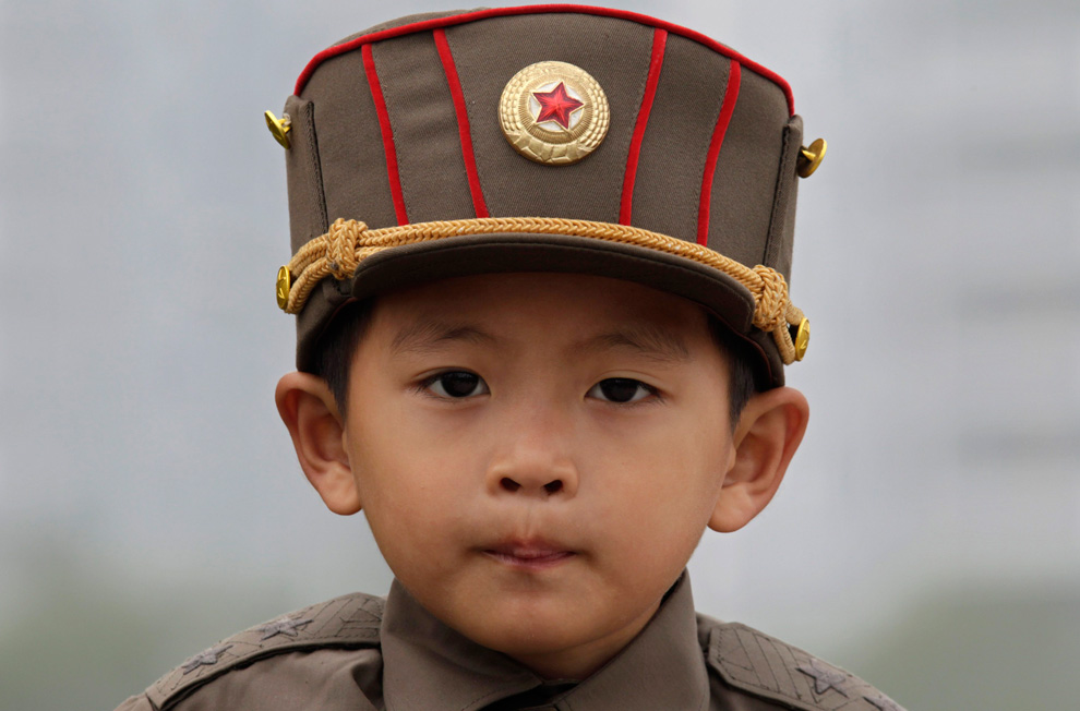 north korean army parade. A boy wears a North Korean