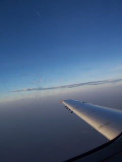 Airplane wing with dark blue sky background in flight