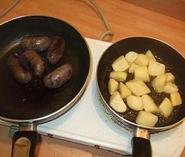 Cooking the butifarra and potatoes