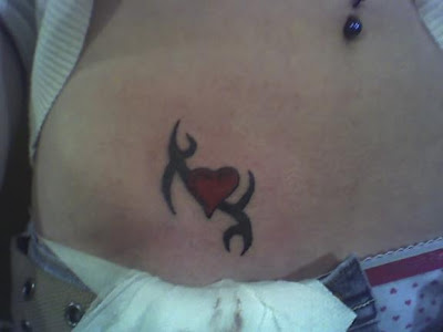 Simply small tribal red heart tattoo on the hip.