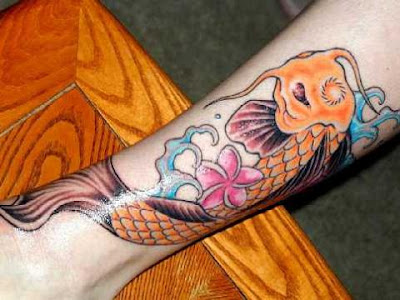 Orange koi fish and pink flower tattoo on leg.