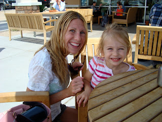 Woman and young girl sitting at outdoor patio seating